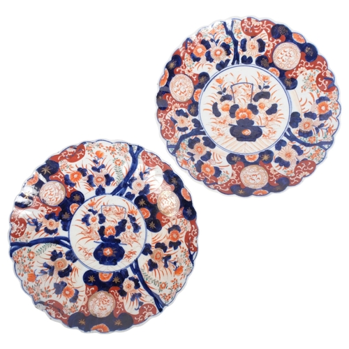 563 - A pair of Imari chargers, with floral decoration and scalloped rims, 30cm (1 has chip to rim)