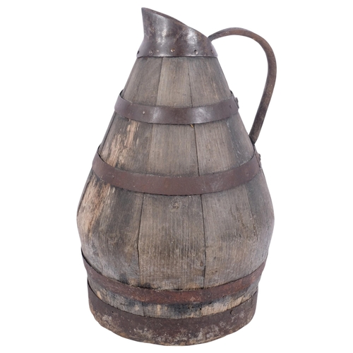 581 - A large Continental coopered oak jug with metal bands, H47cm