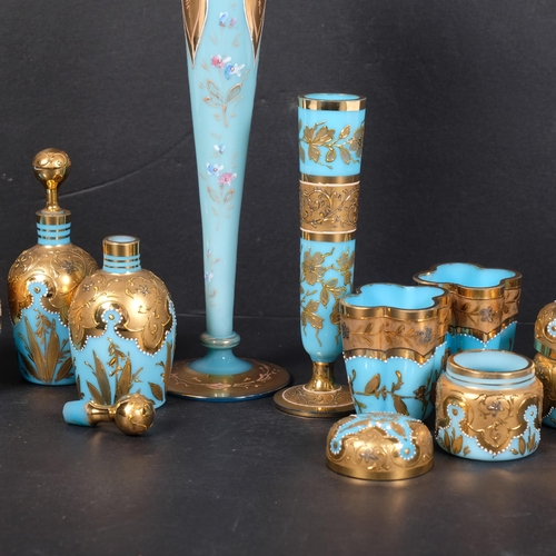 597 - A pair of Vintage blue milk glass bottles and stoppers, with elaborate gilded decoration, matching b... 