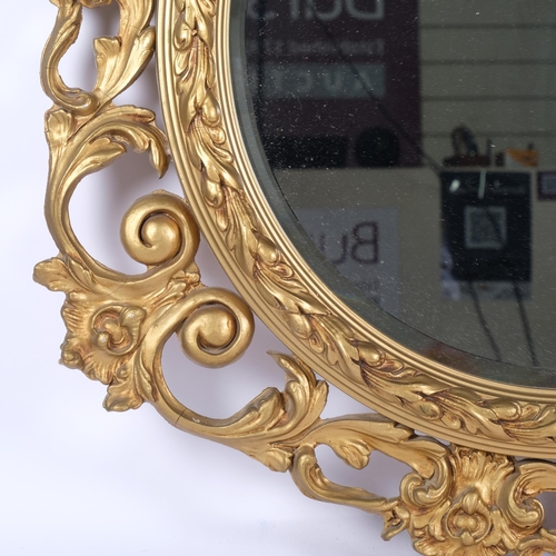 663 - Ornate gilded bevelled-edge wall mirror, in scrolled foliate design frame, 82cm