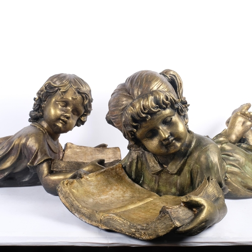 695 - A pair of fibreglass sculptures, boy and girl laying down reading, each measures approx 66cm in leng... 