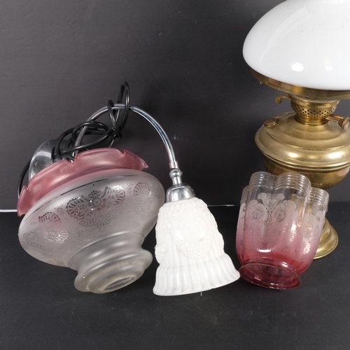 703 - An Antique oil lamp, and a quantity of associated shades, etc