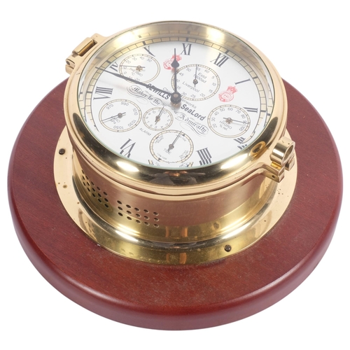 706 - A Sewills SeaLord brass bulkhead clock, with silver dial and brass case, on wooden circular plinth, ... 