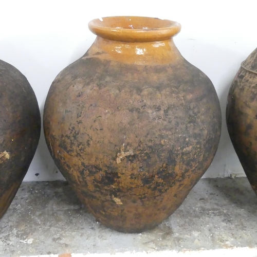 2640 - A glazed terracotta olive oil jar. Diameter 47cm, height 63cm.