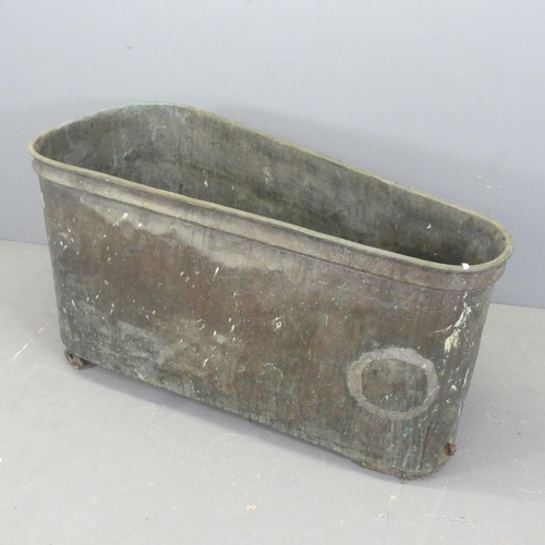 2642 - A zinc lined copper bath, raised on casters. Length 131cm, height 73cm, width (widest) 58cm..