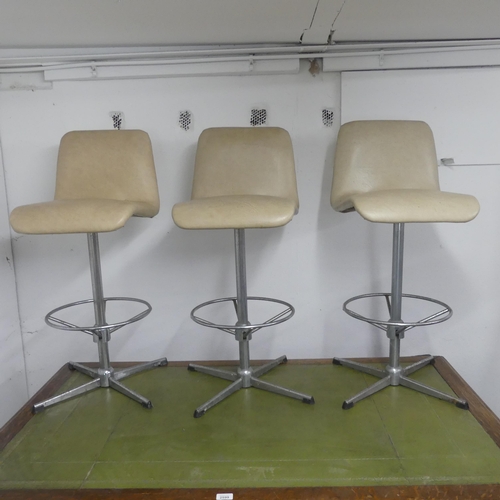 2662 - Three mid-century faux-leather upholstered bar stools on metal bases.