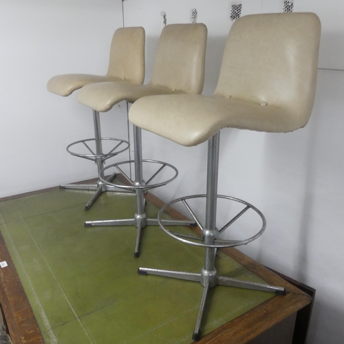 2662 - Three mid-century faux-leather upholstered bar stools on metal bases.