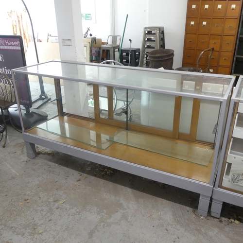 2670 - A vintage glazed shop display cabinet, with rear sliding doors and two adjustable shelves. Width 181... 