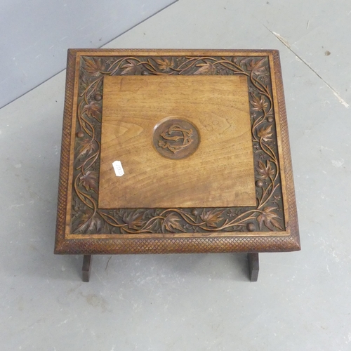 2686 - An early 20th century Arts and Crafts oak foot stool, with carved decoration. Width 35cm, height 42c... 