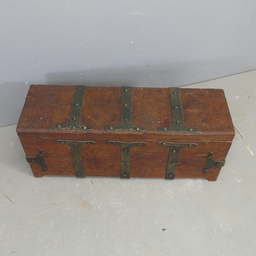 2700 - A metal bound teak trunk, the lid lifting to reveal armorial mythological carved and painted designs... 