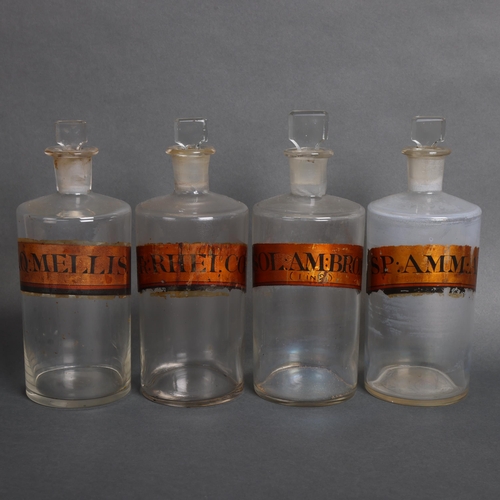 3002 - A group of four clear glass apothecary bottles, each with stopper, all have gold gilt period paper l... 