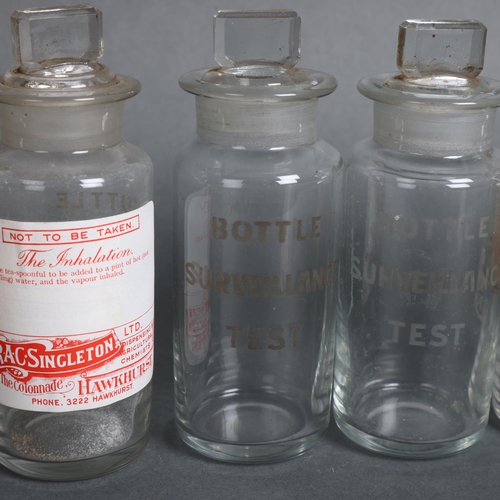 3005 - A group of nine clear glass etched surveillance test bottles with stoppers, some with labels, includ... 