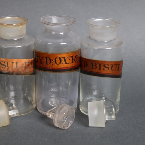 3009 - A group of four clear glass apothecary bottles, each with stopper, all have gold gilt period labels,... 