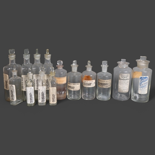 3014 - A group of clear glass apothecary bottles, including rectangular and traditional cylindrical, each w... 