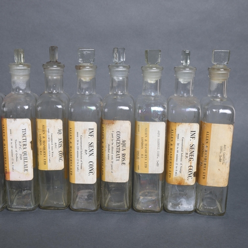 3019 - A group of 20 rectangular clear glass apothecary bottles, all with stoppers, each with period paper ... 