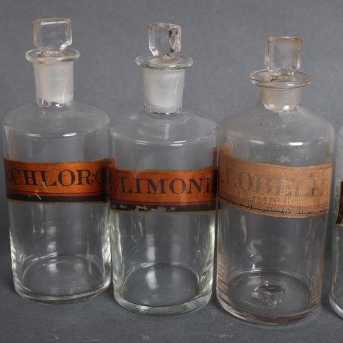 3021 - A group of six clear glass apothecary bottles, each with stoppers, all have period gilt gold labels,... 