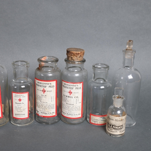 3023 - A group of clear glass apothecary bottles, some corked and labelled, some with glass stoppers, varyi... 