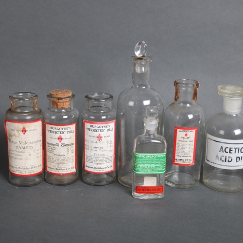 3023 - A group of clear glass apothecary bottles, some corked and labelled, some with glass stoppers, varyi... 