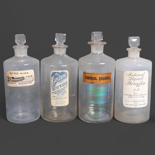 3029 - A group of four clear glass apothecary bottles, each with stopper, all with period paper labelling, ... 