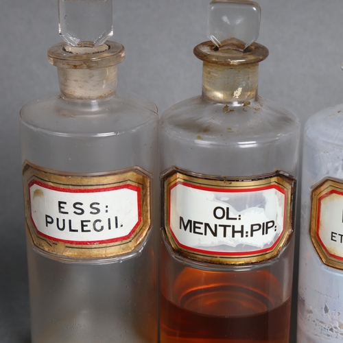 3041 - A group of four clear glass apothecary bottles, each with stopper, all have glass and gilt lettered ... 