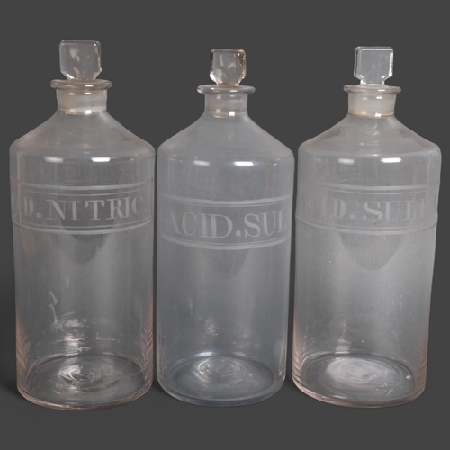 3042 - A group of three large clear glass apothecary bottles, each with stopper, etched labelled contents, ... 