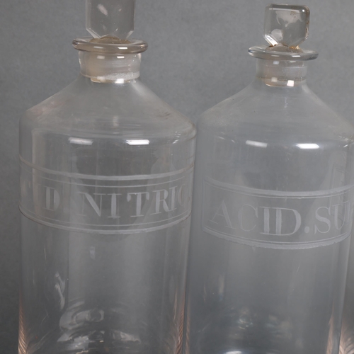 3042 - A group of three large clear glass apothecary bottles, each with stopper, etched labelled contents, ... 