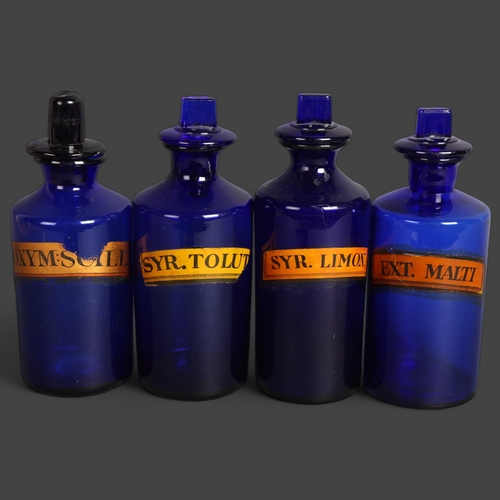 3047 - A group of four blue glass apothecary bottles with stoppers, each has paper label, largest height 22... 