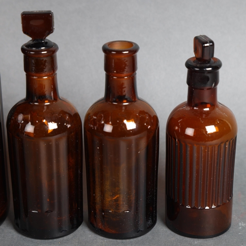 3050 - A group of four brown glass apothecary bottles, one large and three small, largest with stopper and ... 