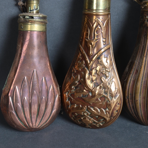 3106 - A group of four copper and brass mounted powder flasks, (4).