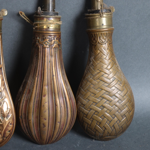 3106 - A group of four copper and brass mounted powder flasks, (4).