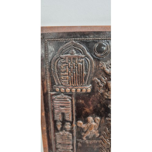 189 - A 19th century Tibetan Thangka, a repousse decorated copper panel depicting Buddhas with script, pan... 