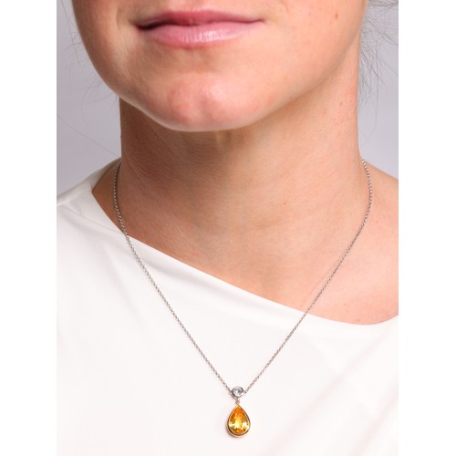 59 - A Yellow Sapphire and Diamond Pendant Necklace,

the teardrop pendant rub-over set with pear-cut yel... 