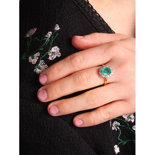 69 - An Emerald and Diamond Ring,

the oval cluster set with an oval mixed-cut emerald of approximately 1... 