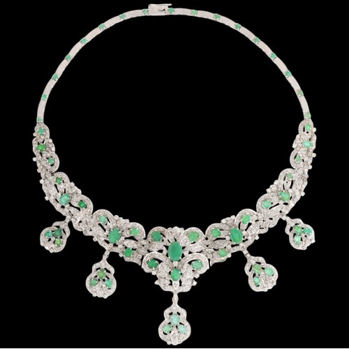 70 - An Emerald and Diamond Necklace,

the graduated floral scrollwork collar claw-set with oval mixed-cu... 