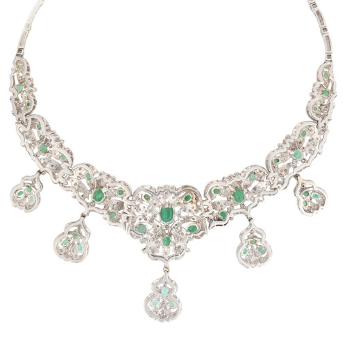 70 - An Emerald and Diamond Necklace,

the graduated floral scrollwork collar claw-set with oval mixed-cu... 