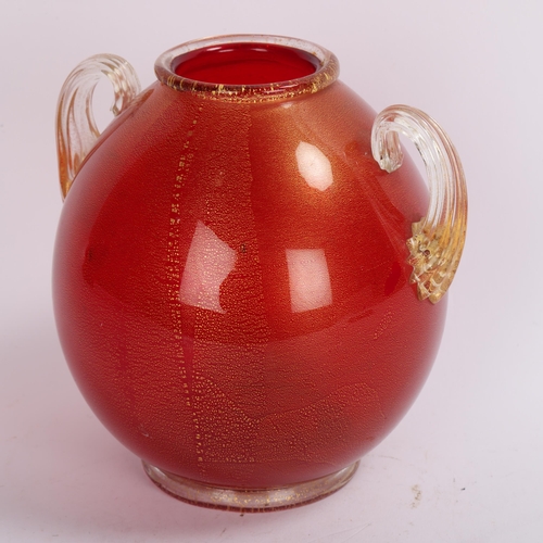 132 - Seguso Vetri d’Arte (Murano), a red vase on foot with gold leaf with scrolled handles, 1950s' produc... 