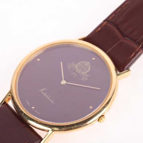 1021 - KUTCHINSKY - an 18ct gold 'Saudi Arabia Emblem' quartz wristwatch, maroon dial with gilt quarterly d... 