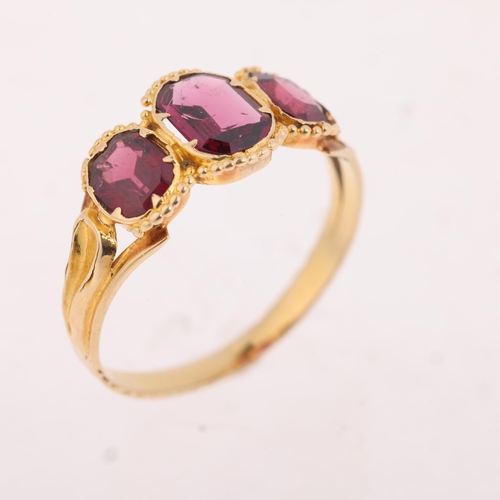 1121 - An Antique Georgian three-stone garnet ring, collet set with octagonal step-cut garnets, within bead... 