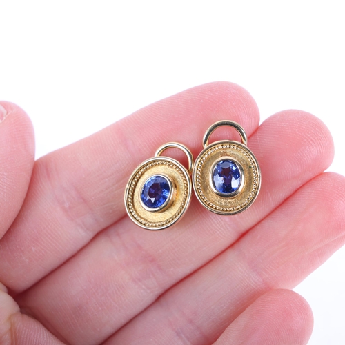 1144 - A pair of 18ct gold sapphire earrings, each rub-over set with a 0.65ct oval mixed-cut sapphire withi... 