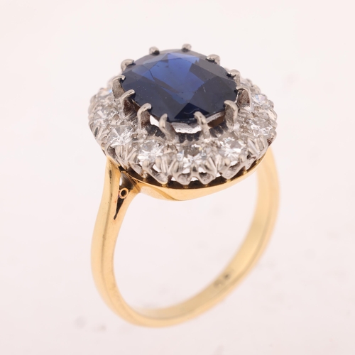 1145 - An 18ct gold sapphire and diamond cluster ring, claw set with 3.7ct oval mixed-cut sapphire surround... 