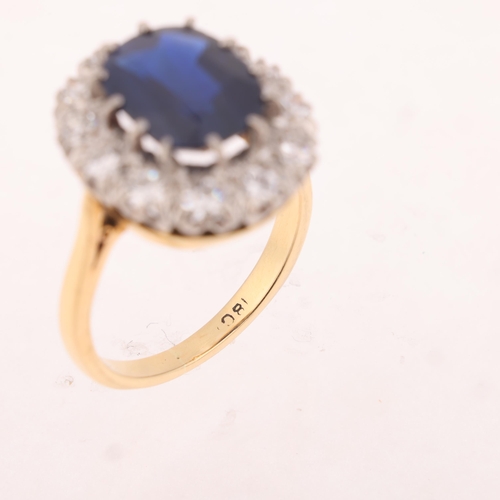 1145 - An 18ct gold sapphire and diamond cluster ring, claw set with 3.7ct oval mixed-cut sapphire surround... 