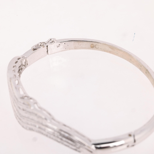 1180 - A 9ct white gold diamond hinged bangle, channel set with baguette-cut diamonds, total diamond conten... 