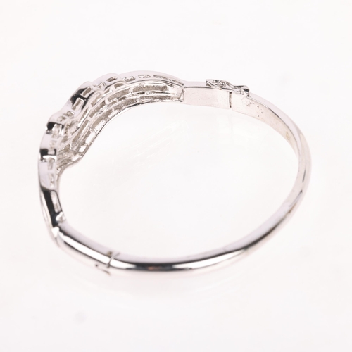 1180 - A 9ct white gold diamond hinged bangle, channel set with baguette-cut diamonds, total diamond conten... 