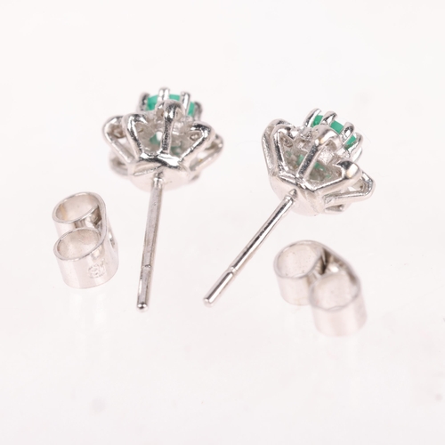 1192 - A pair of 18ct white gold emerald and diamond flowerhead cluster stud earrings, set with round-cut e... 