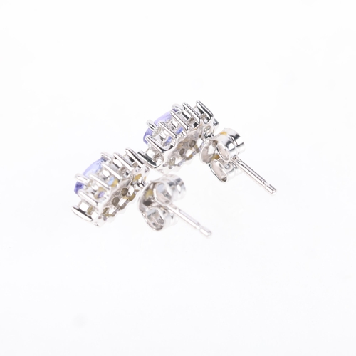 1194 - A pair of 9ct white gold tanzanite and diamond cluster stud earrings, claw set with oval mixed-cut t... 