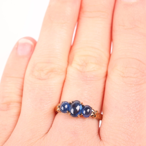 1255 - A 9ct gold three stone sapphire ring, claw set with oval cabochon sapphires, setting height 6.8mm, s... 