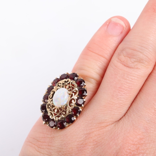 1258 - A 9ct gold opal and garnet openwork cluster ring, maker B Brothers, London 1976, the oval cluster cl... 