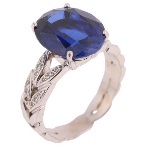 1275 - An 18ct white gold synthetic sapphire and diamond dress ring, claw set with oval mixed-cut sapphire ... 