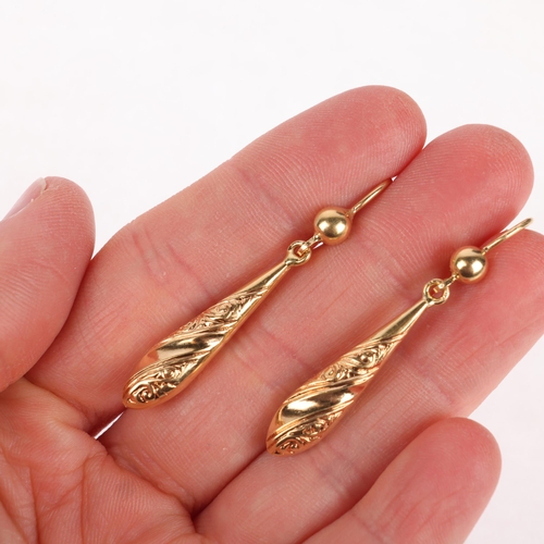 1324 - A pair of 18ct gold drop earrings, the torpedo drops with relief embossed scrollwork decoration and ... 