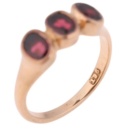 1330 - An Antique 9ct rose gold three stone garnet ring, rub-over set with oval mixed-cut garnets, setting ... 